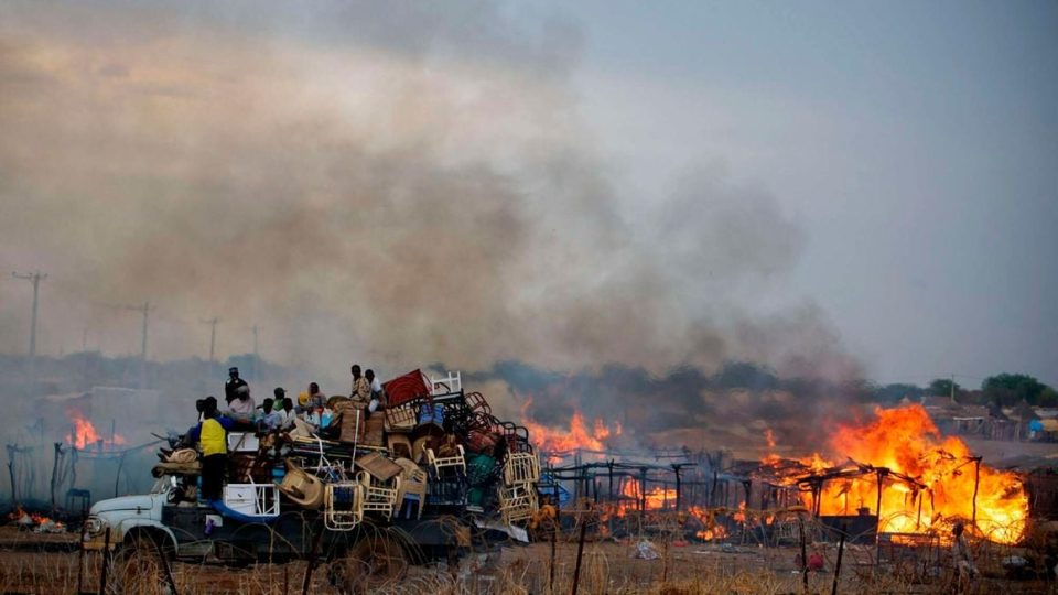 A truck piled high with looted items as it drives past businesses and homesteads burning in the center of the disputed border town of Abyei on May 28, 2011. PHOTO | AFP